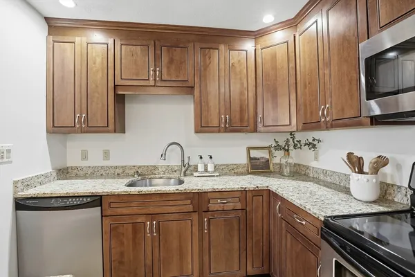 a kitchen with stainless steel appliances granite countertop a sink dishwasher stove and cabinets