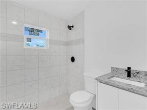 4330 Gulfstream Drive Naples, FL 34112 - Photo 15 of 15 a bathroom with a granite countertop sink a toilet and shower