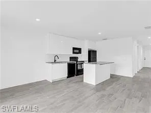 a view of a kitchen with microwave and sink