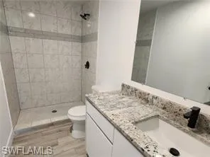 a bathroom with a granite countertop sink toilet and shower