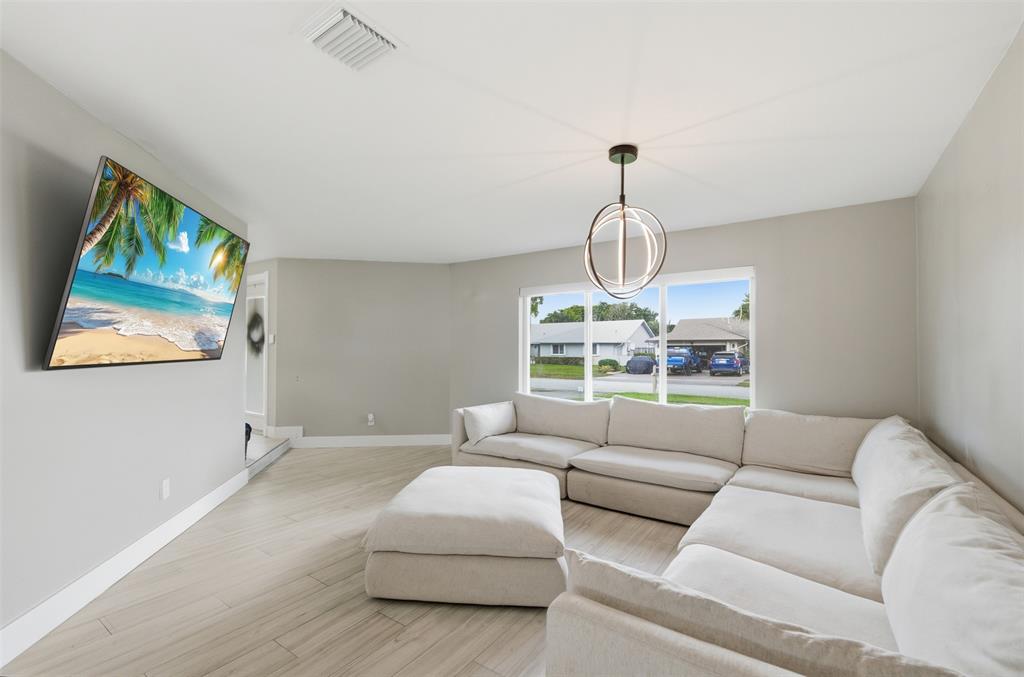 8340 Southwest 27th Place Davie, FL 33328 - Photo 3 of 25 a living room with furniture a window and a chandelier