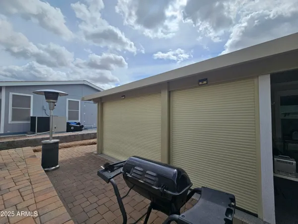 a backyard of a house with barbeque oven and outdoor seating