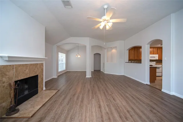 a view of a livingroom with wooden floor and a fireplace