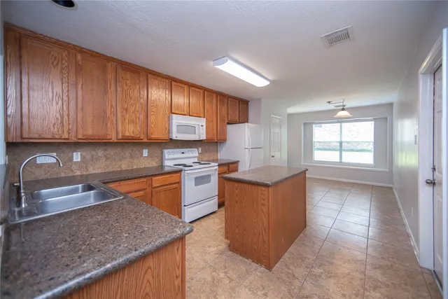 a kitchen with stainless steel appliances granite countertop wooden cabinets a sink and dishwasher