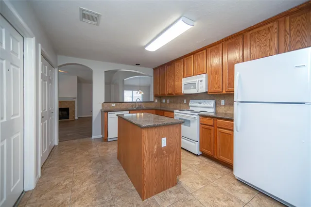 a kitchen with stainless steel appliances granite countertop a stove a refrigerator a sink and dishwasher