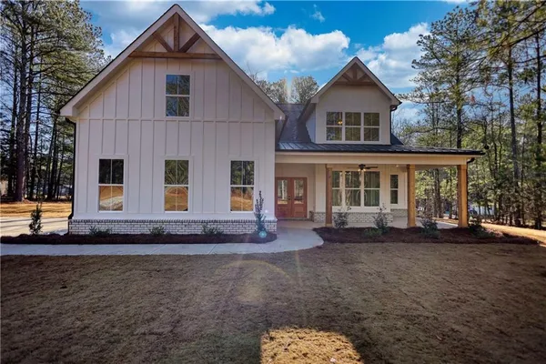 a view of a house with backyard and trees