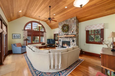 a living room with fireplace furniture and a large window