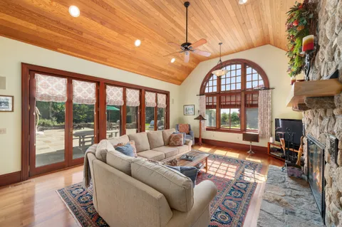 a living room with furniture large window and wooden floor