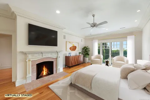 a bedroom with bed a flat screen tv and a fireplace