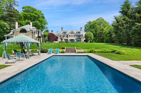a view of a house with a swimming pool and sitting area