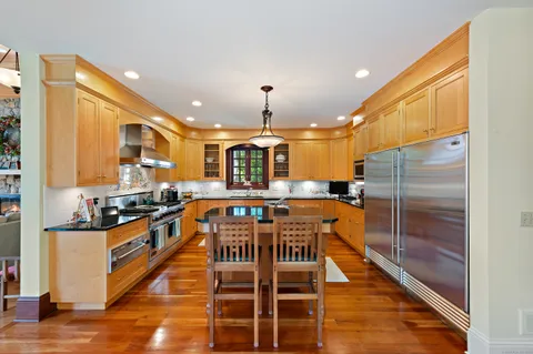 a kitchen with stainless steel appliances granite countertop a stove a sink and a refrigerator