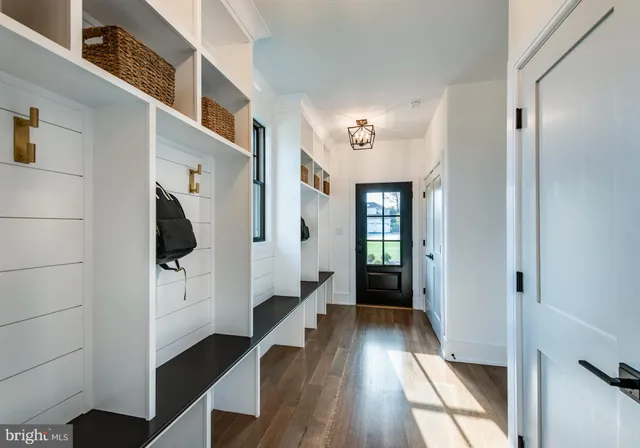a hallway with white doors wooden floor and stairs