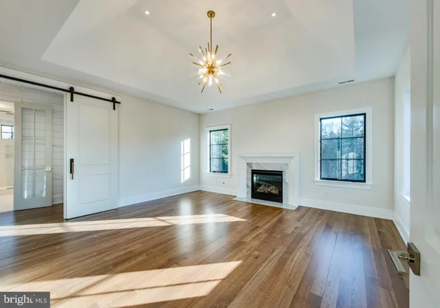 wooden floor fireplace and windows in an empty room