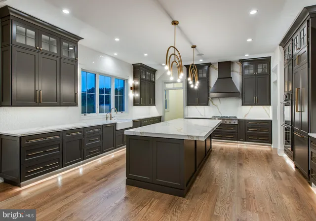 a large kitchen with stainless steel appliances granite countertop a lot of counter space and wooden floor