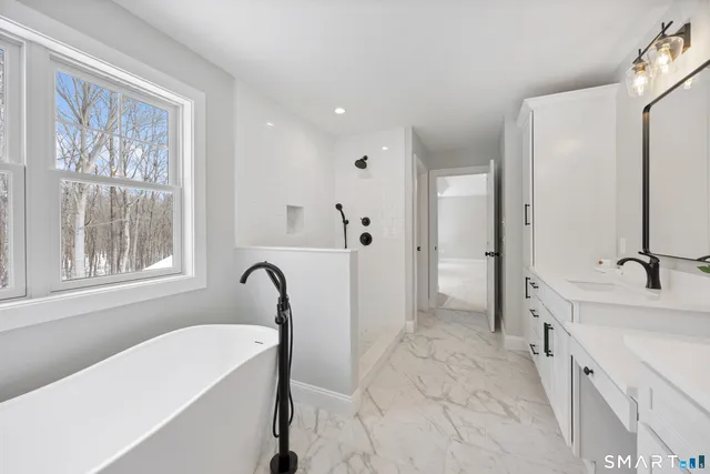 a bathroom with a tub sink and mirror