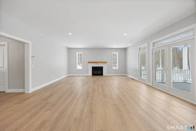 wooden floor fireplace and windows in an empty room