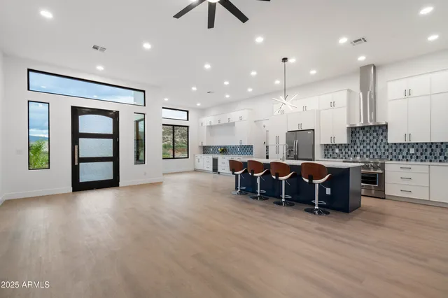 a kitchen with kitchen island granite countertop a sink a counter space stainless steel appliances and cabinets