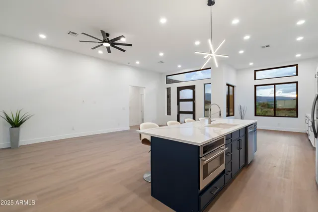 an empty room with a ceiling fan and wooden floor