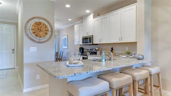 a kitchen with granite countertop a sink a counter top space and living room view