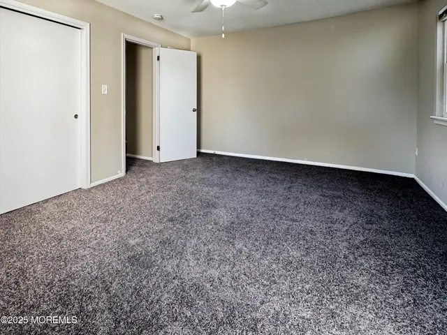 a view of a room with a ceiling fan and a window