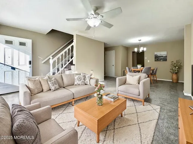 a living room with furniture a ceiling fan and a rug