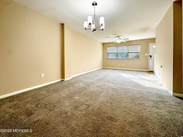 a dining room with wooden floor and a chandelier