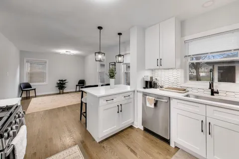 a large kitchen with kitchen island a sink stainless steel appliances and cabinets