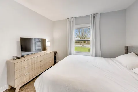 a bedroom with a bed and a flat screen tv