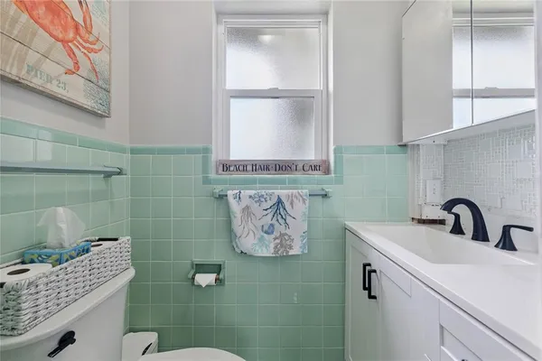 a bathroom with a sink a toilet and mirror