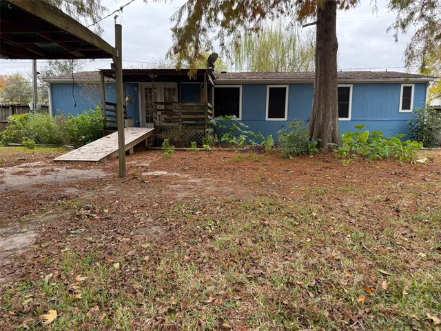 a view of a house with backyard and trees