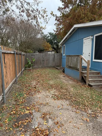 a view of a house with a small yard and wooden fence