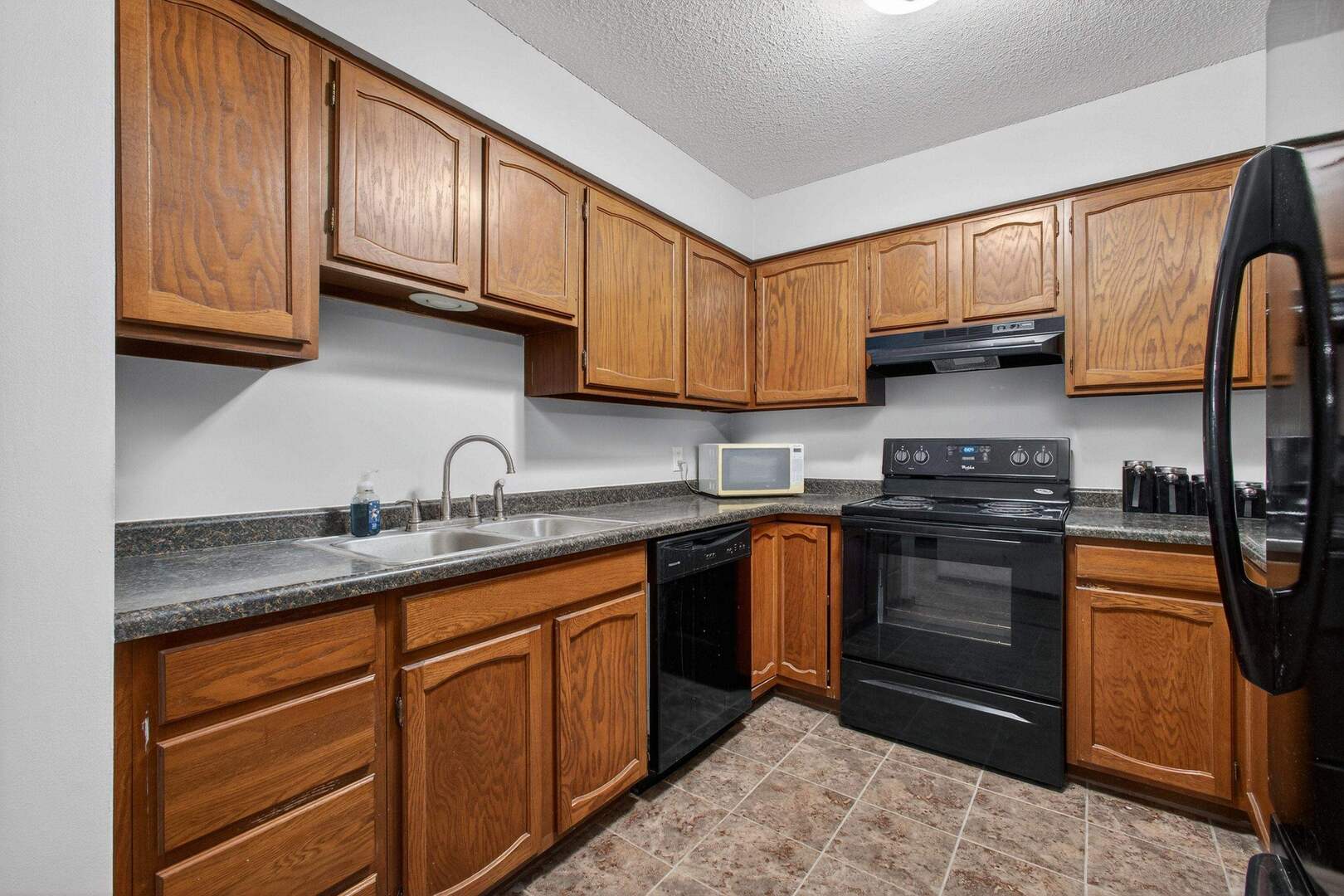800 East Iowa Street, Unit 2C Eldridge, IA 52748 - Photo 12 of 28 a kitchen with granite countertop wooden cabinets stainless steel appliances and a sink