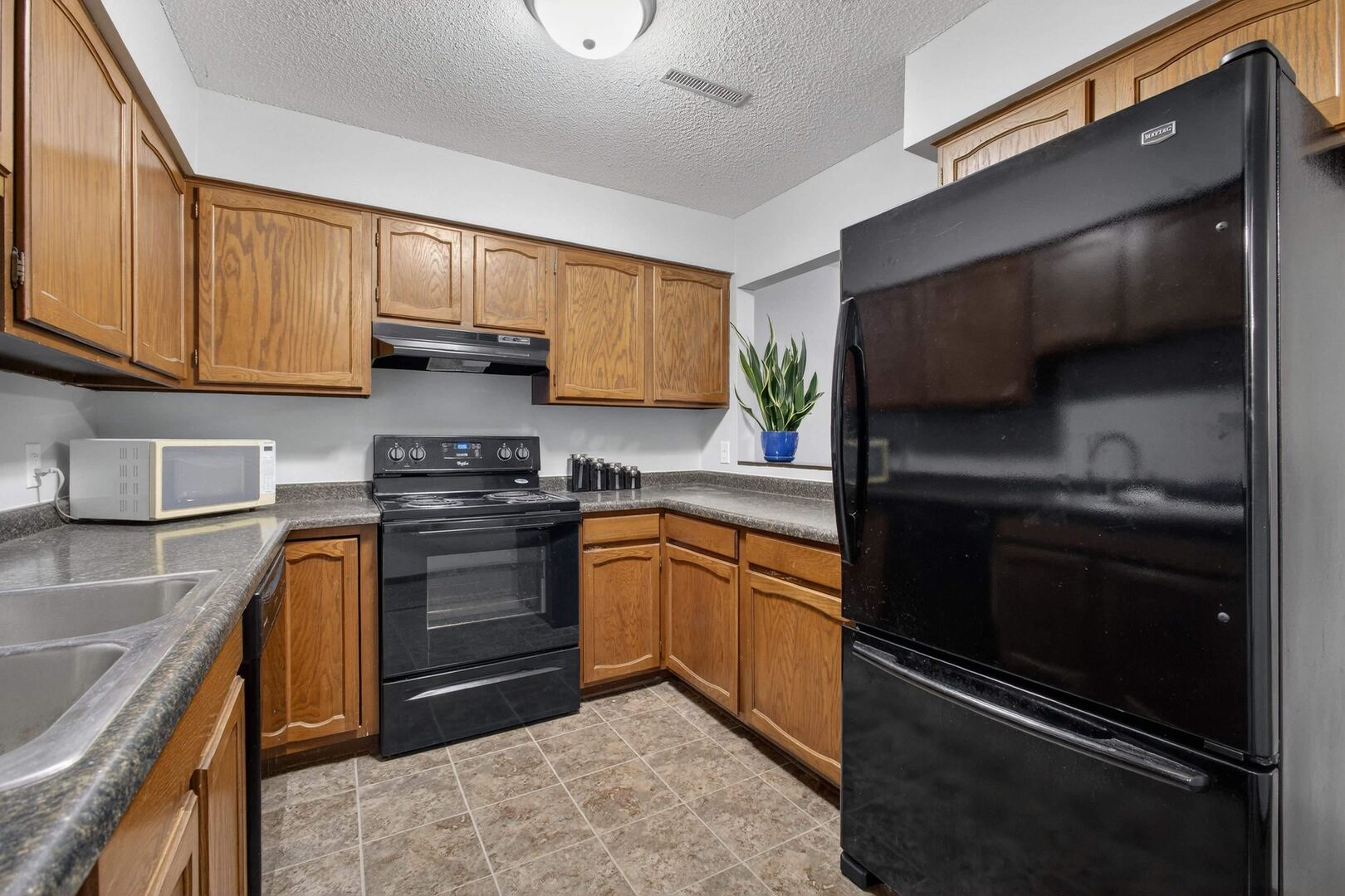 800 East Iowa Street, Unit 2C Eldridge, IA 52748 - Photo 13 of 28 a kitchen with granite countertop stainless steel appliances and wooden cabinets