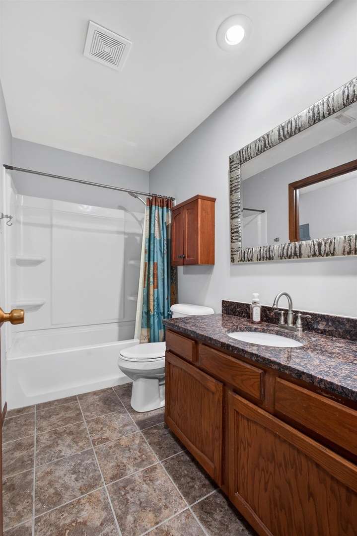 800 East Iowa Street, Unit 2C Eldridge, IA 52748 - Photo 17 of 28 a bathroom with a granite countertop sink toilet a mirror and bathtub