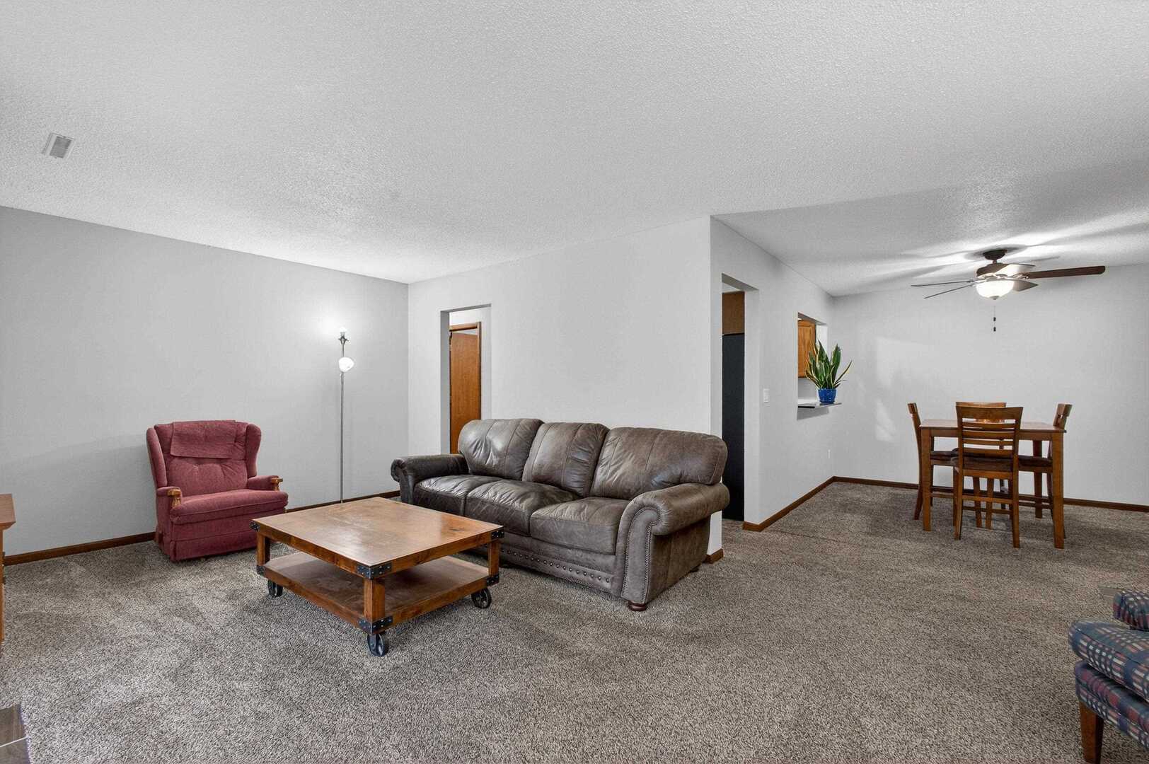 800 East Iowa Street, Unit 2C Eldridge, IA 52748 - Photo 3 of 28 a living room with furniture a ceiling fan and a window