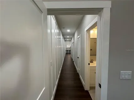 a view of a hallway with wooden floor and staircase