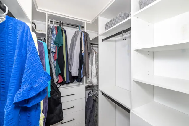 a view of walk in closet with clothes