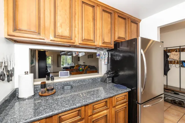 a kitchen with granite countertop a refrigerator and a sink
