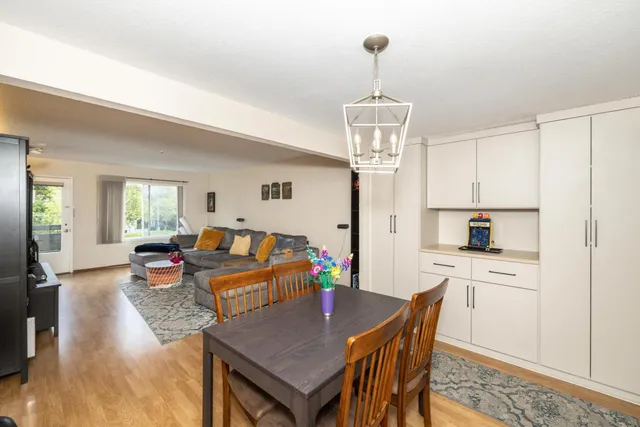 a view of a dining room and livingroom with furniture wooden floor a chandelier