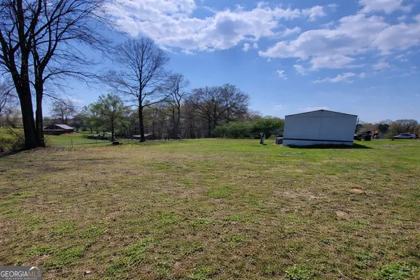 a view of a field of grass and trees