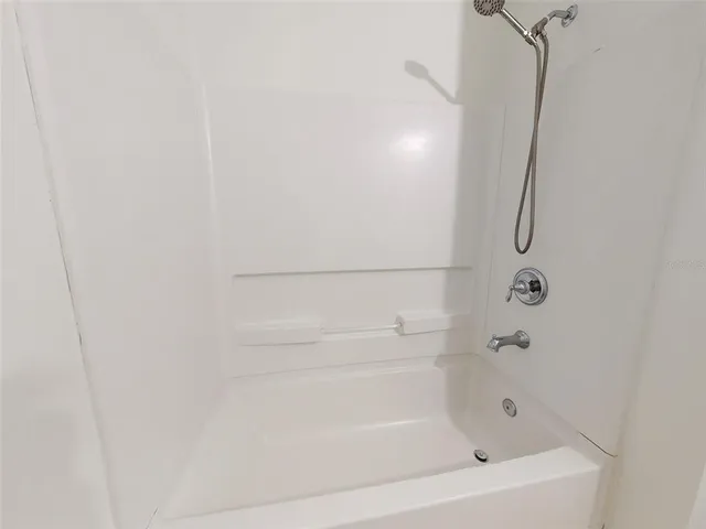a spacious bathroom with a granite countertop sink a mirror and shower