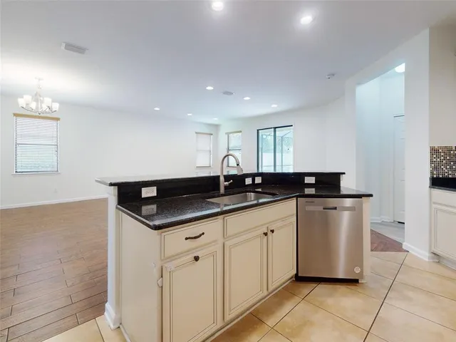 a kitchen with granite countertop a sink a stove and cabinets