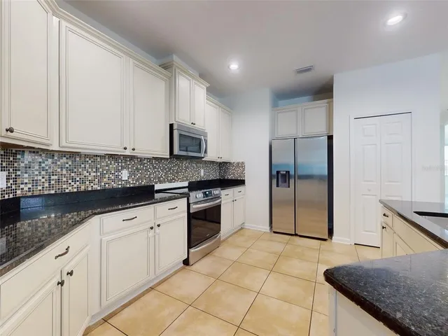 a view of kitchen with granite countertop refrigerator and a sink