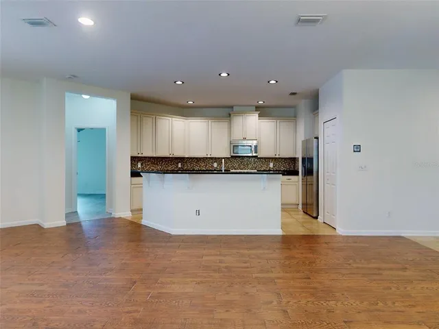 a view of kitchen with stainless steel appliances granite countertop a refrigerator a sink and a stove
