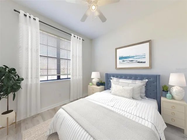 a bedroom with a large bed and a potted plant