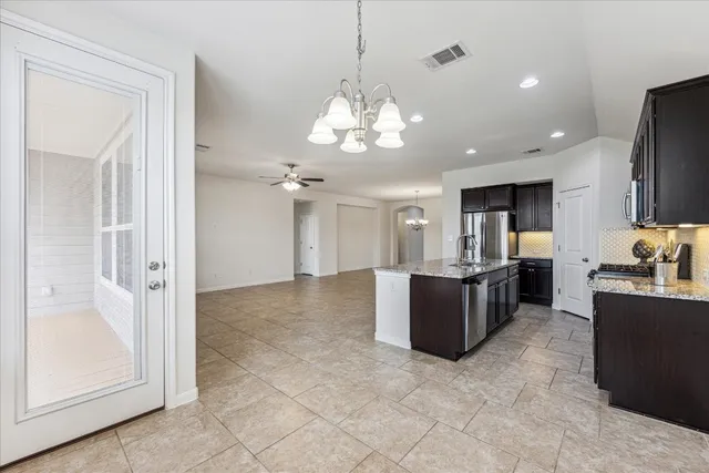 a large kitchen with a refrigerator a stove top oven a sink and dishwasher