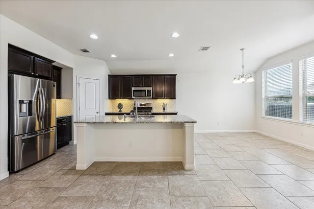 a kitchen with stainless steel appliances granite countertop a refrigerator and a sink