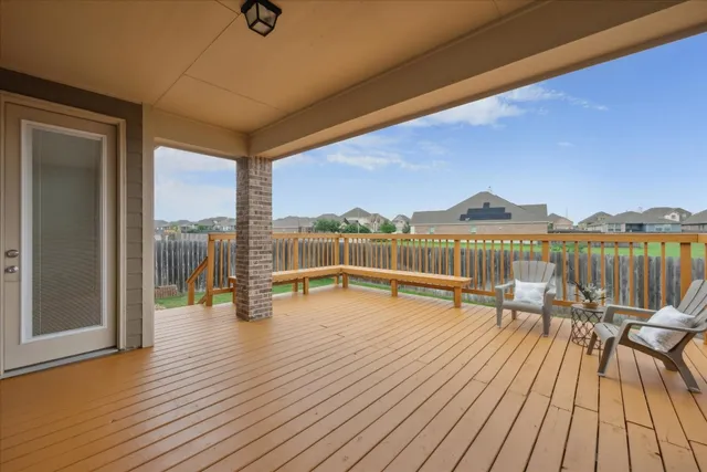 a view of a balcony with wooden floor and seating space