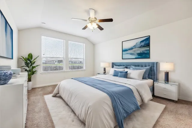 a bedroom with a large bed couch and a large window