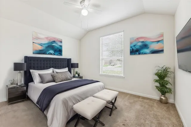 a bedroom with bed and a painting on the wall